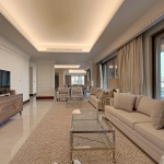A long, luxurious living room with a TV and sofas