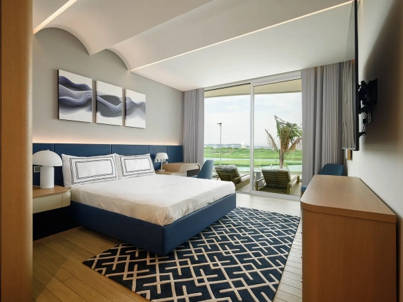 A bedroom with a bed, TV, and balcony.