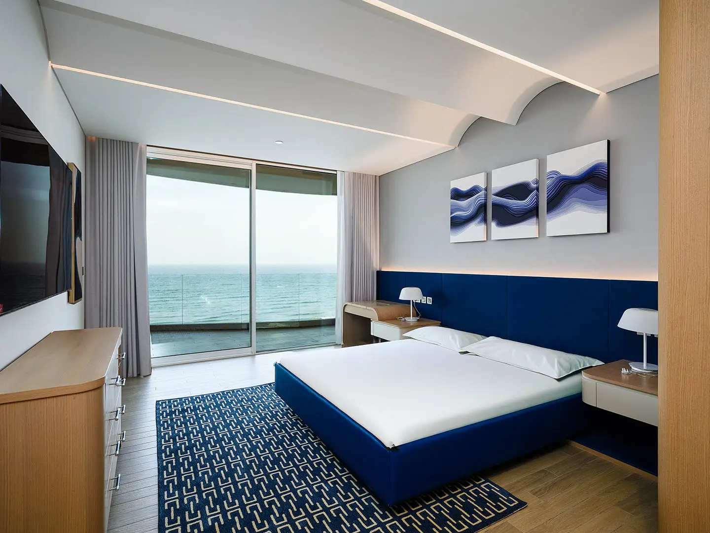 A bright bedroom with ocean view balcony