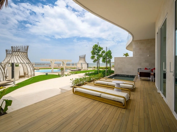 A luxury outdoor patio with lounges, a pool, and sea view